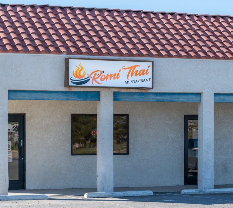 Exterior view of Romi Thai Restaurant with a sign above the entrance and two doors visible.
