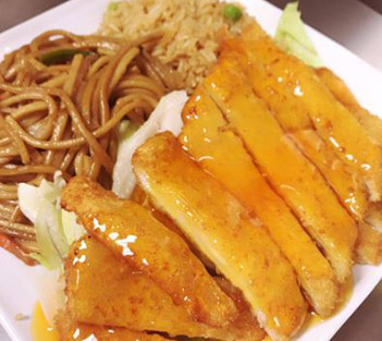 Breaded chicken with orange sauce, noodles, and fried rice served on a white plate.