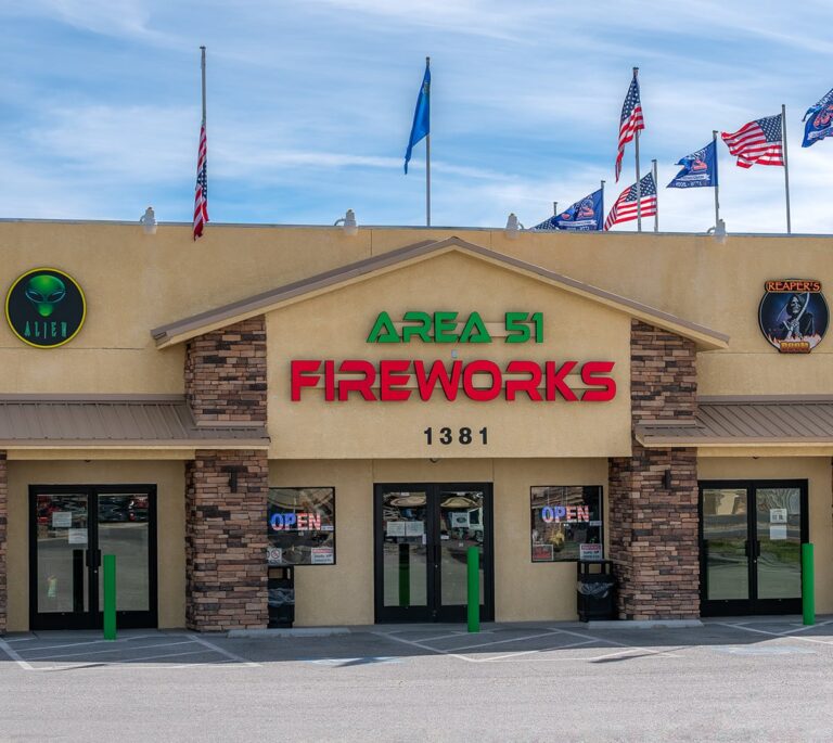 Area 51 Fireworks store with flags on roof, stone pillars, and open signs in the windows.