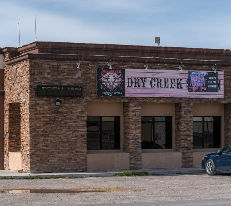 A stone building with signs reading Dry Creek and Teen Night Fridays 8:00 PM to Midnight.