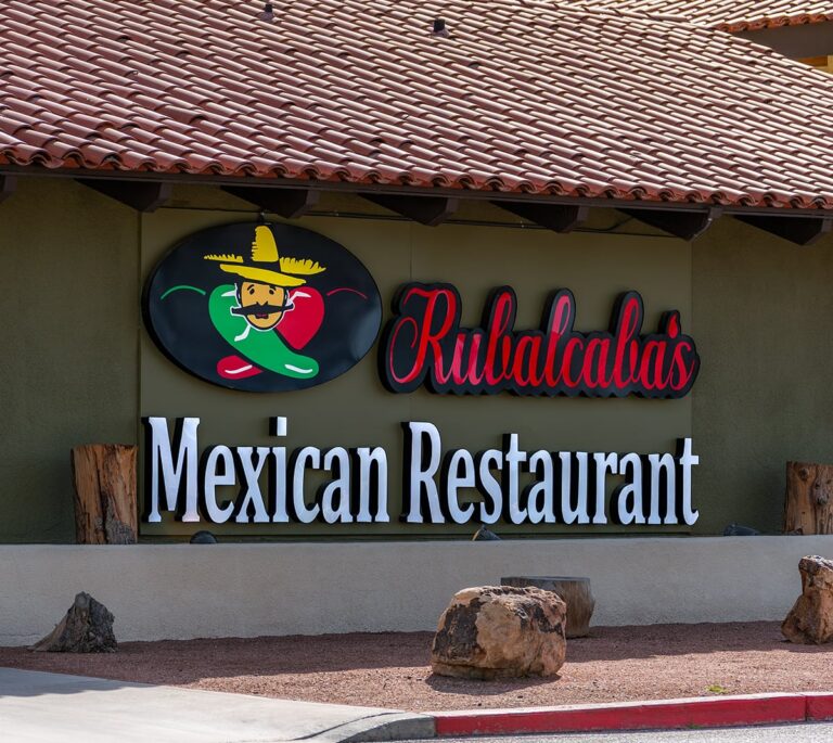 Rubalcaba’s Mexican Restaurant sign with a smiling chili pepper wearing a sombrero on the building exterior.