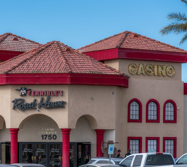 A beige casino building with red trim, arched entry, and a sign reading Terribles Road House.