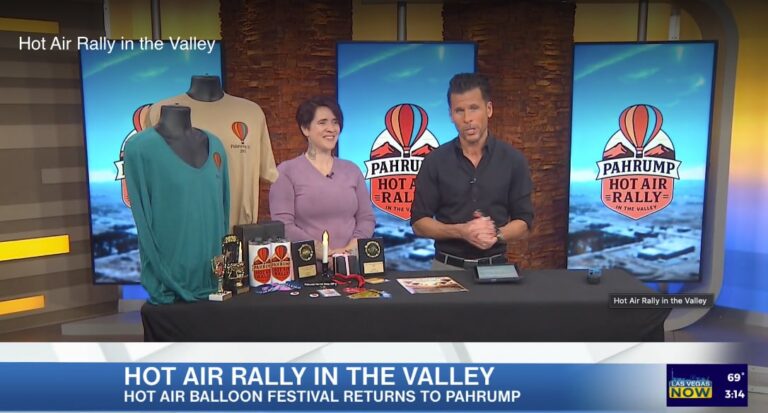 Two people discuss the Hot Air Rally in the Valley event on a news show, with festival merchandise displayed.