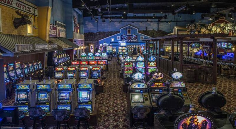 Rows of illuminated gaming machines inside Gold Town Casino's western-themed slot floor.