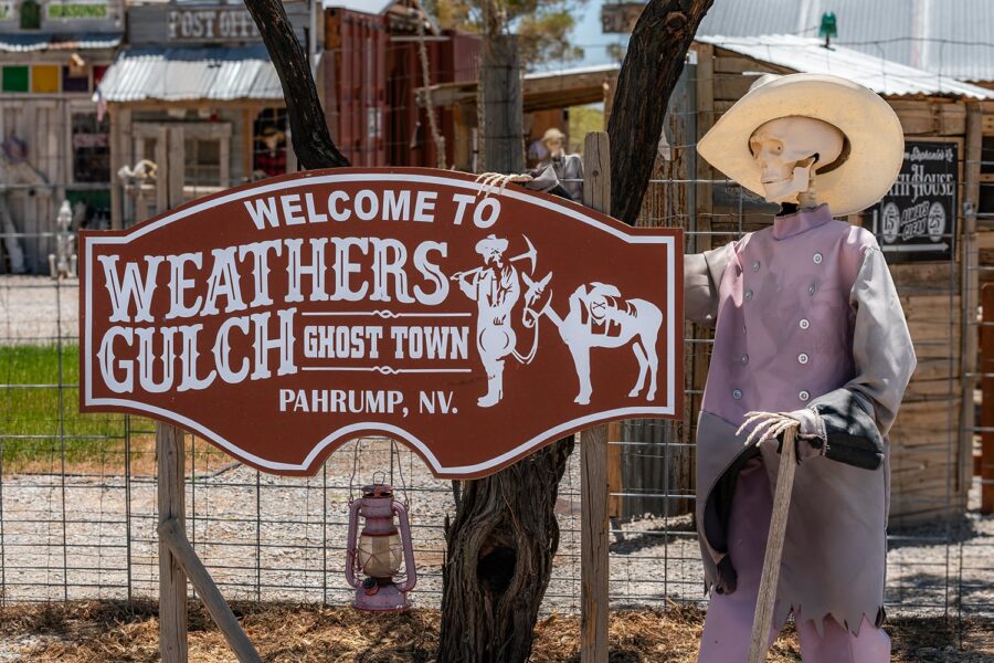 A skeleton in a cowboy hat stands by a “Weathers Gulch Ghost Town” sign in Pahrump, NV.