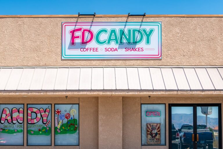 Storefront of FD Candy shop with colorful sign, window art, and an OPEN sign on the door.