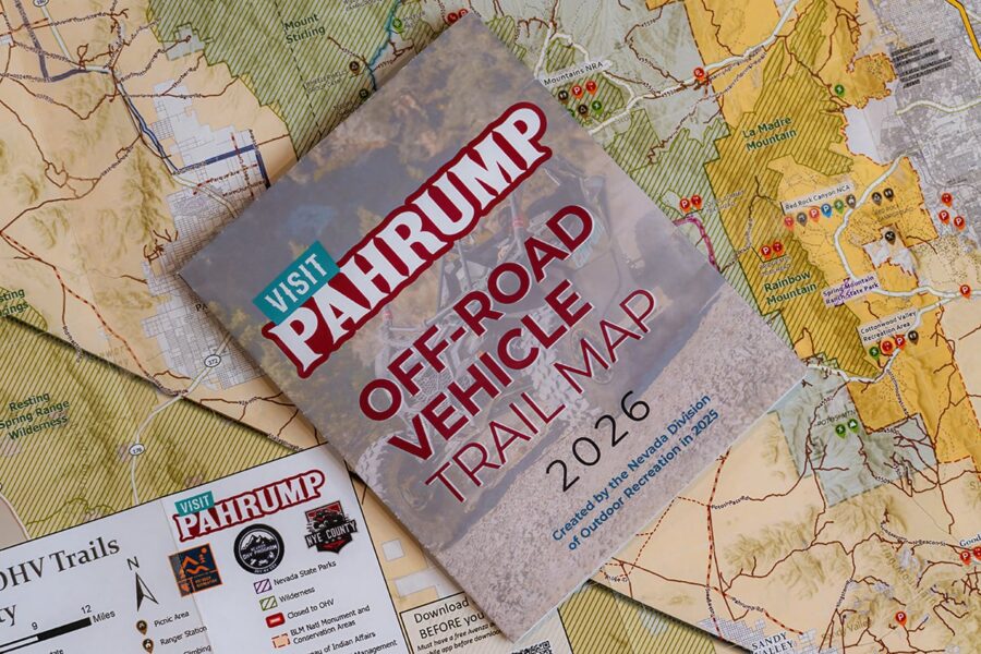 An off-road vehicle trail map for Pahrump, Nevada, lies on top of detailed regional maps and brochures.